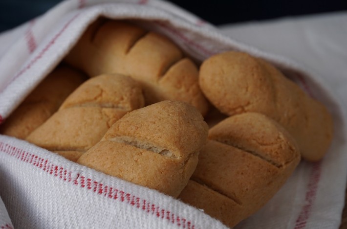 Brytbröd i en brödkorg med kökshandduk runt