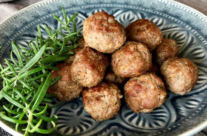 lammköttbullar på tallrik tillsammans med en kvist rosmarin