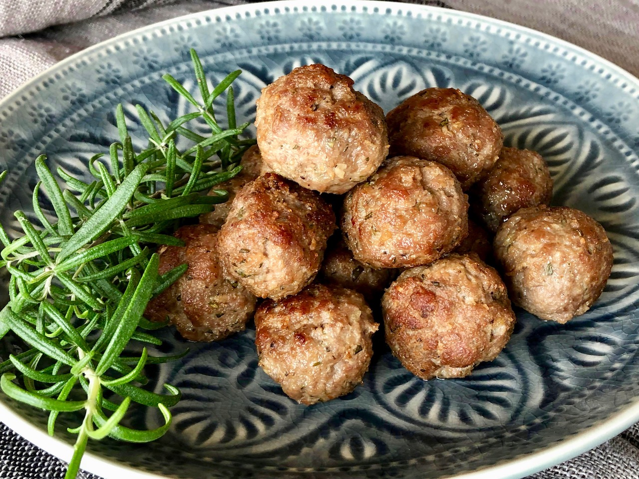 lammköttbullar på tallrik tillsammans med en kvist rosmarin