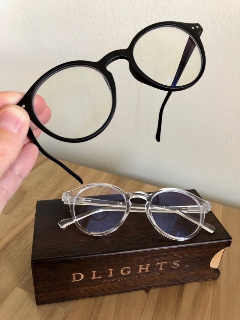 Två par blåljusblockerande glasögon från DLIGHTS tillsammans med en träask