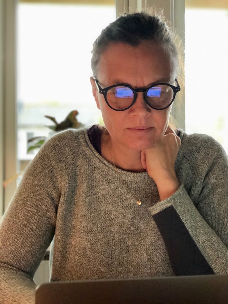 Sitter framför datorn med blåljusblockerande glasögon