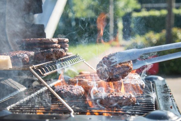 Grillas hamburgare på en kolgrill