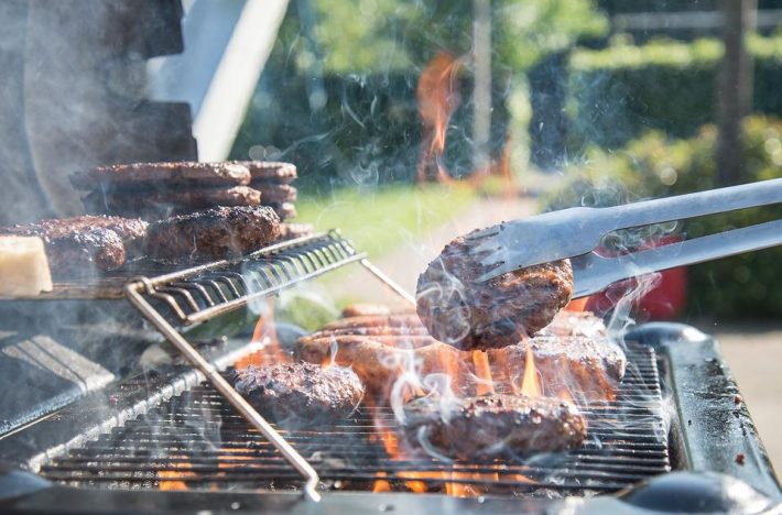 Grillas hamburgare på en kolgrill